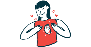 A smiling woman wearing a shirt with a heart on it holds her hands to her chest.