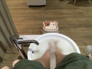 A woman soaks her feet in bath oils.