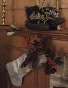 A stocking hangs from a mantel with gifts in it.